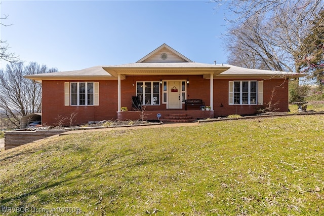 ranch-style house featuring brick siding, a porch, and a front lawn