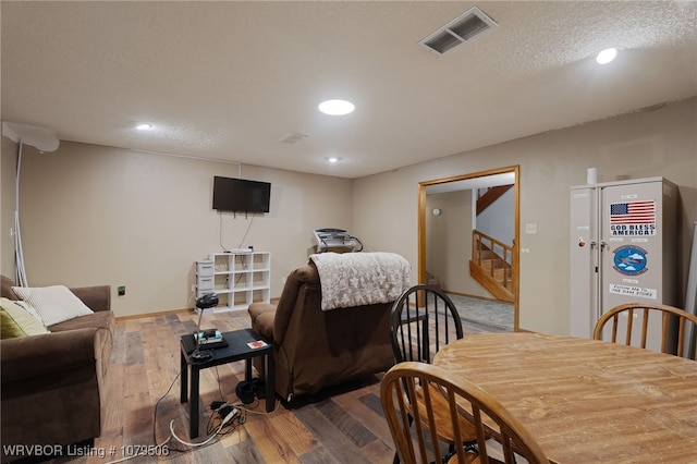 living room with visible vents, recessed lighting, stairs, and wood finished floors