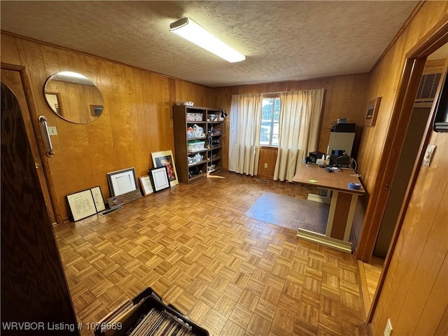 unfurnished office featuring light parquet floors, a textured ceiling, and wood walls