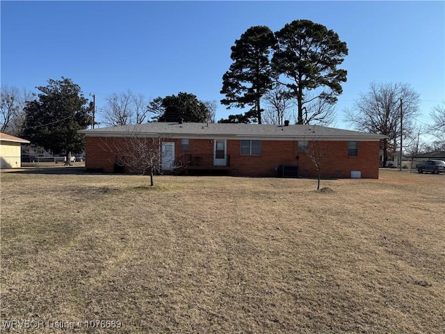 back of house featuring central AC unit and a lawn