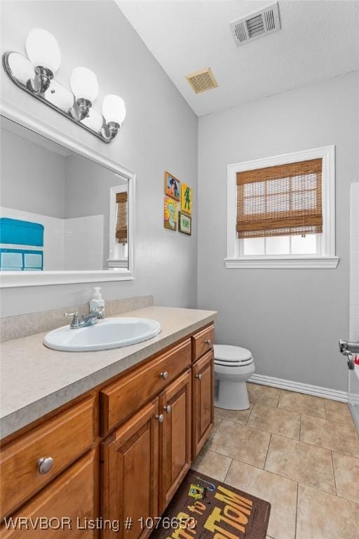 bathroom featuring tile patterned flooring, vanity, and toilet