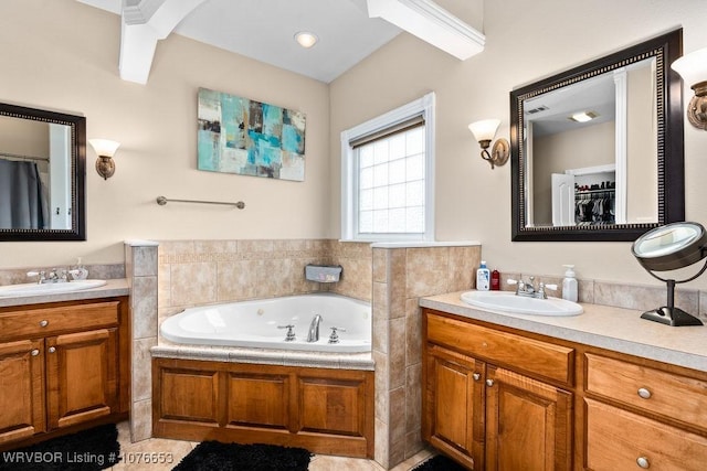 bathroom featuring tile patterned flooring, vanity, and a bath