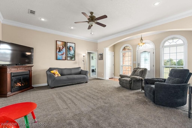 living room featuring ceiling fan, light colored carpet, ornate columns, and crown molding