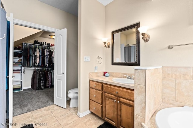 bathroom featuring a bathing tub, tile patterned flooring, vanity, and toilet