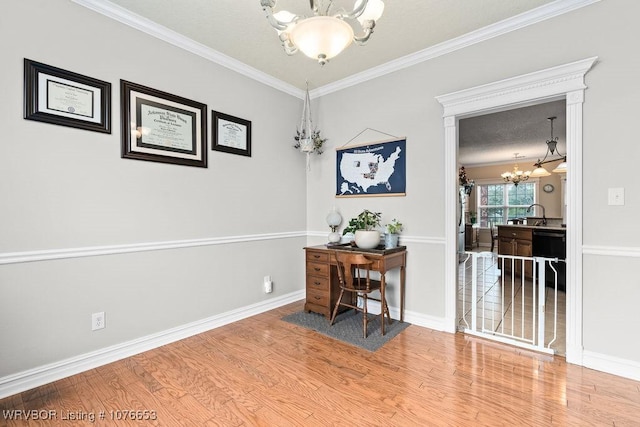 office area featuring hardwood / wood-style floors, a notable chandelier, ornamental molding, and sink