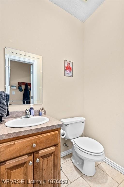 bathroom featuring tile patterned flooring, vanity, and toilet