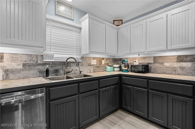 kitchen with white cabinets, decorative backsplash, sink, and dishwasher