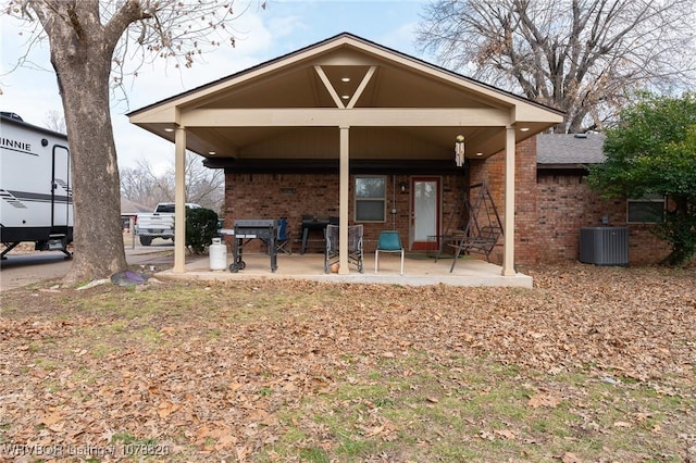 rear view of property with central air condition unit and a patio area