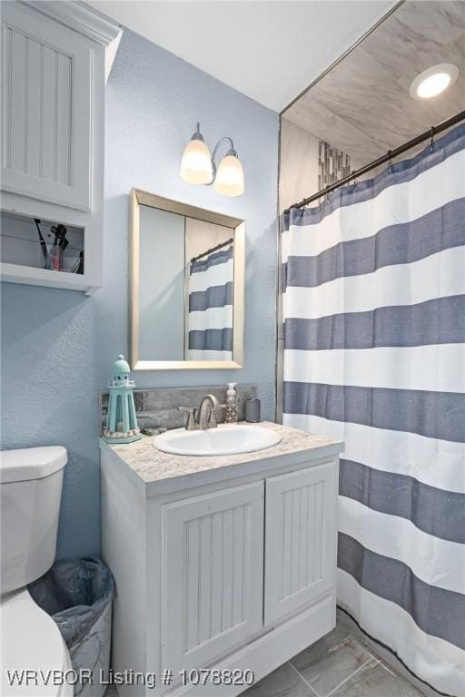 bathroom with vanity, curtained shower, and toilet