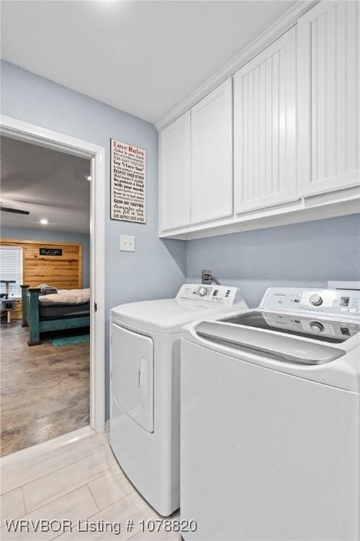 laundry room featuring cabinets, washer and dryer, and light hardwood / wood-style floors