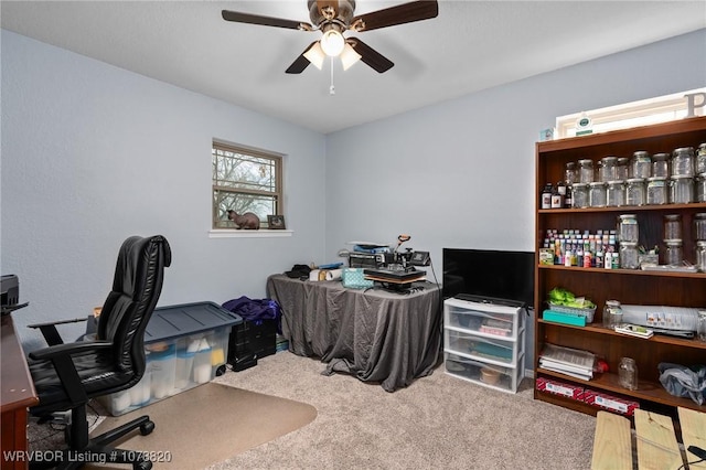 carpeted home office featuring ceiling fan