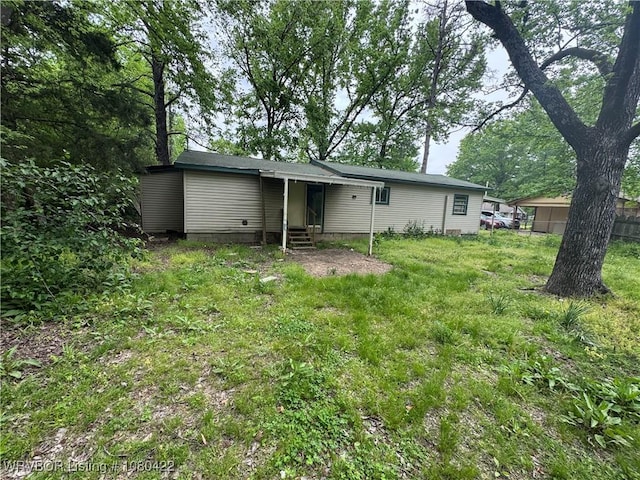 rear view of property featuring fence and entry steps