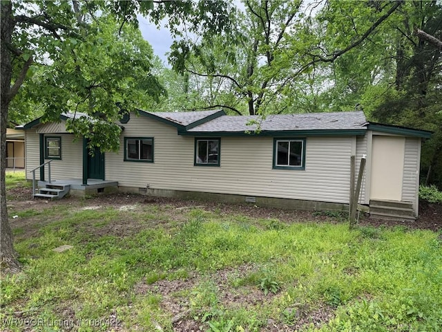 rear view of house featuring crawl space and a shingled roof