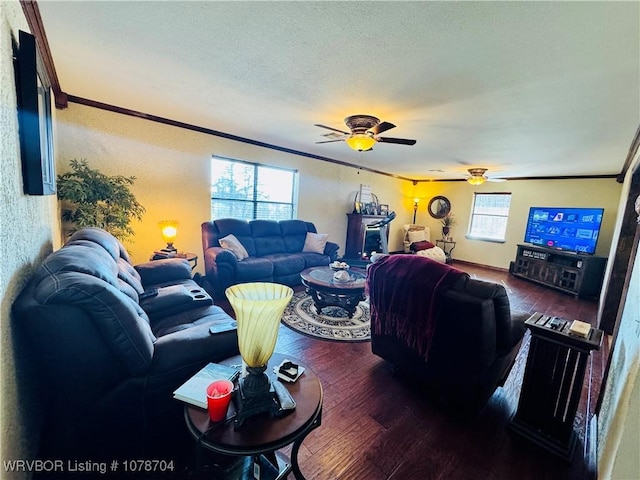 living room with dark wood-type flooring, ceiling fan, crown molding, and a textured ceiling