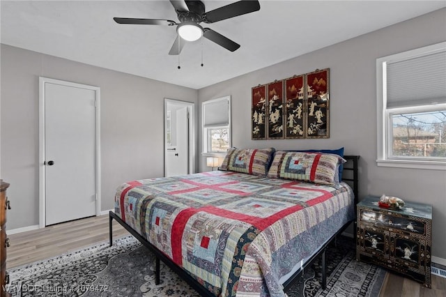 bedroom featuring ceiling fan, baseboards, and wood finished floors