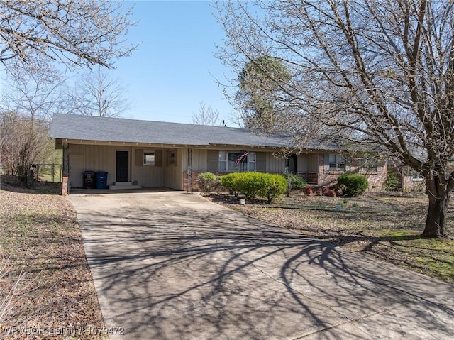 ranch-style house featuring an attached carport and driveway