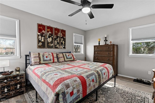 bedroom with ceiling fan, baseboards, and wood finished floors