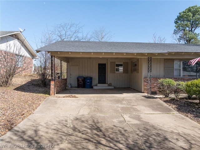 view of front of house with driveway, brick siding, a shingled roof, a carport, and board and batten siding