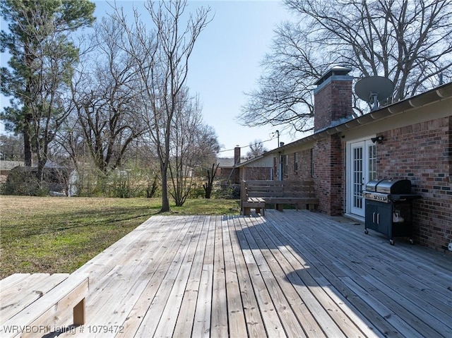 deck featuring a lawn and a grill