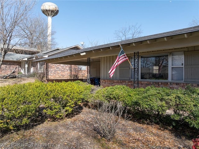 exterior space featuring brick siding and covered porch