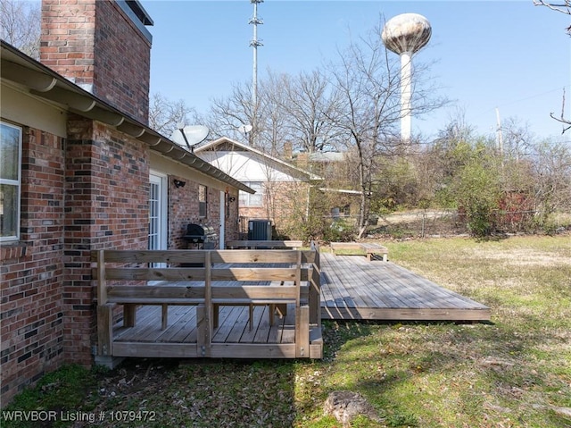 wooden deck featuring a lawn