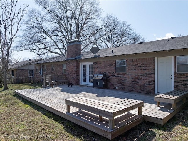 wooden deck featuring french doors, a yard, and area for grilling