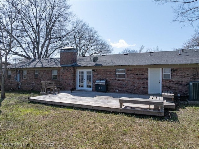 rear view of house featuring brick siding, a lawn, french doors, cooling unit, and a deck