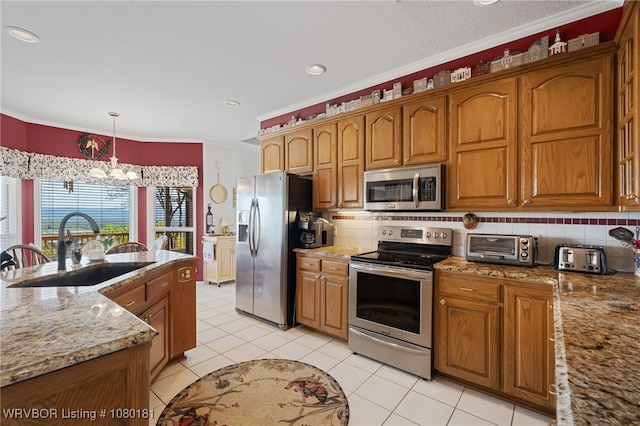 kitchen featuring brown cabinetry, decorative backsplash, stainless steel appliances, and a sink