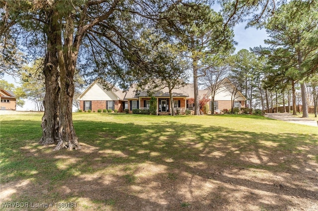 view of front facade with brick siding and a front yard