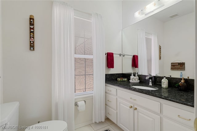 bathroom with visible vents, toilet, vanity, and tile patterned floors