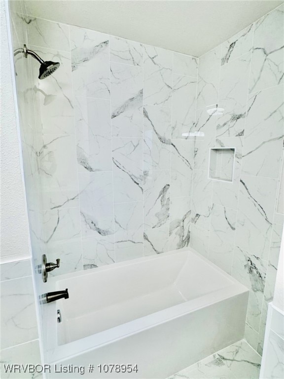 full bath featuring marble finish floor and shower / washtub combination