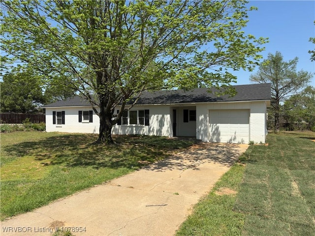 ranch-style home featuring an attached garage, concrete driveway, fence, and a front lawn
