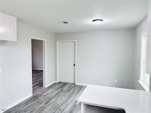 unfurnished dining area featuring light hardwood / wood-style floors and a textured ceiling