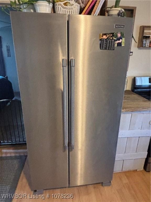 details with stainless steel fridge and light hardwood / wood-style floors