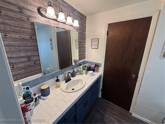 bathroom featuring vanity, wood-type flooring, and a textured ceiling