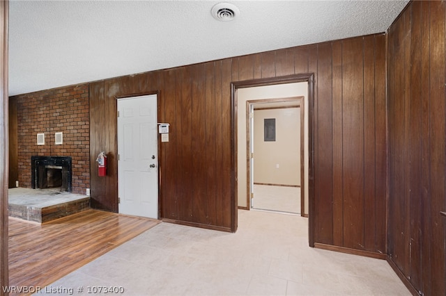 hallway featuring a textured ceiling and wooden walls