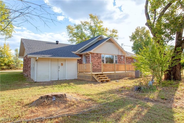 rear view of house with a yard and a wooden deck