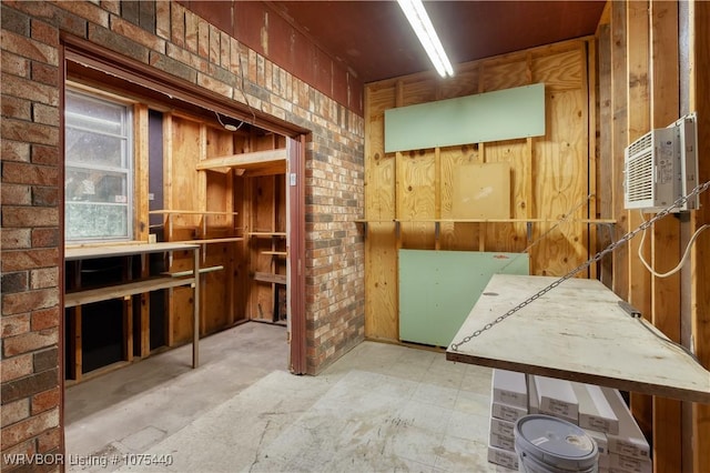 miscellaneous room with an AC wall unit and brick wall