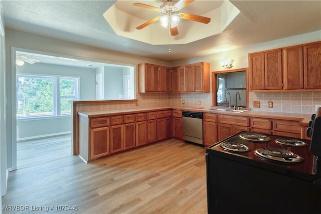 kitchen with dishwasher, sink, a raised ceiling, tasteful backsplash, and tile countertops