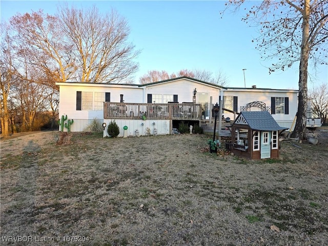 back of property with a yard and a wooden deck