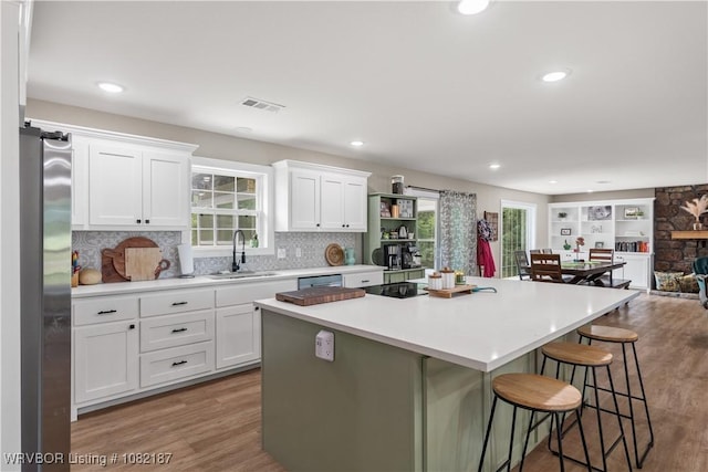 14008 White Bluff Rd, Fort Smith, AR 72916 - kitchen with stainless steel appliances, wood finished floors, a kitchen island, a kitchen breakfast bar, and recessed lighting