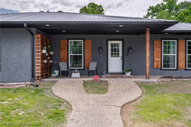 14008 White Bluff Rd, Fort Smith, AR 72916 - view of exterior entry with stucco siding, covered porch, and a metal roof