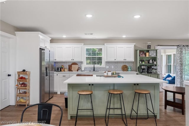 14008 White Bluff Rd, Fort Smith, AR 72916 - kitchen with stainless steel refrigerator with ice dispenser, a kitchen breakfast bar, white cabinets, light countertops, and recessed lighting