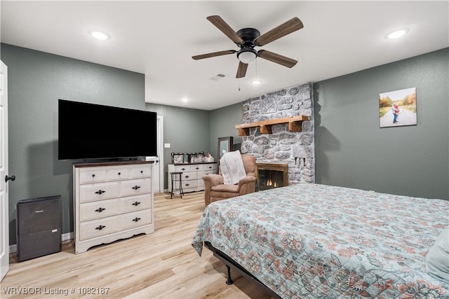 14008 White Bluff Rd, Fort Smith, AR 72916 - bedroom with light wood finished floors, recessed lighting, a stone fireplace, and a ceiling fan