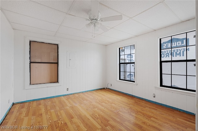 unfurnished room featuring wood-type flooring, a drop ceiling, and ceiling fan