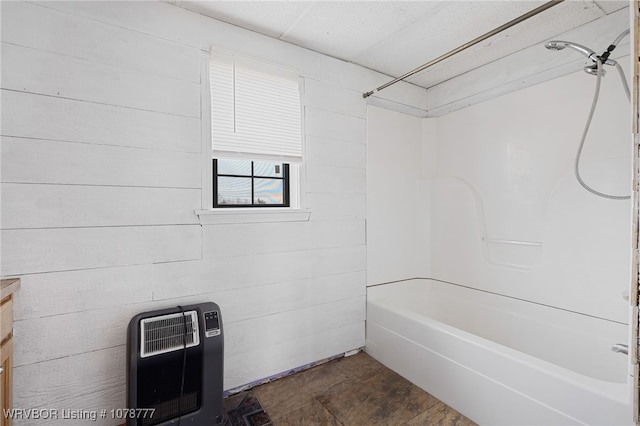 bathroom featuring vanity, tub / shower combination, heating unit, and wood walls