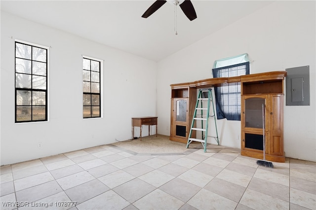 spare room with light tile patterned floors, vaulted ceiling, electric panel, and ceiling fan