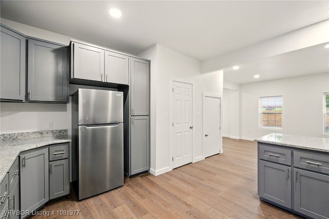 925 Cedar St, Van Buren, AR 72956 - kitchen with freestanding refrigerator, gray cabinets, light wood-type flooring, recessed lighting, and light stone countertops