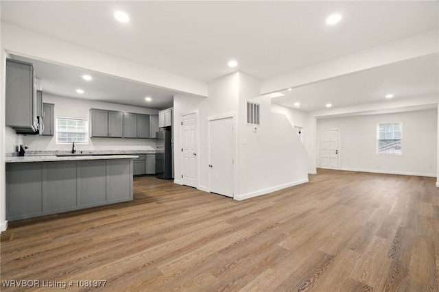 925 Cedar St, Van Buren, AR 72956 - kitchen with gray cabinetry, open floor plan, recessed lighting, freestanding refrigerator, and light wood-style flooring
