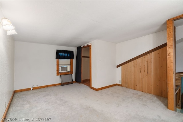 unfurnished room featuring carpet, cooling unit, and wooden walls